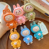 Set of colorful cartoon keychains shaped like bunnies on a wooden surface.