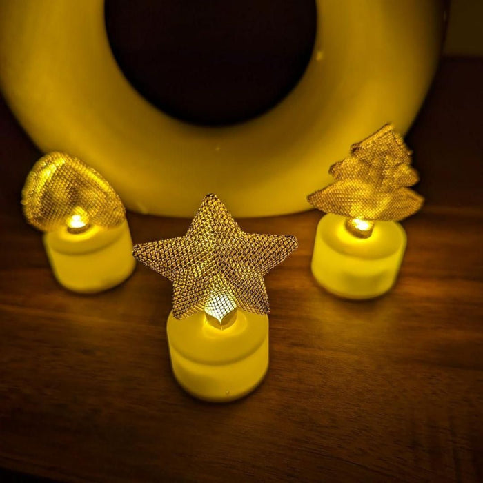 Decorative string lights with star and tree shapes on a wooden surface.