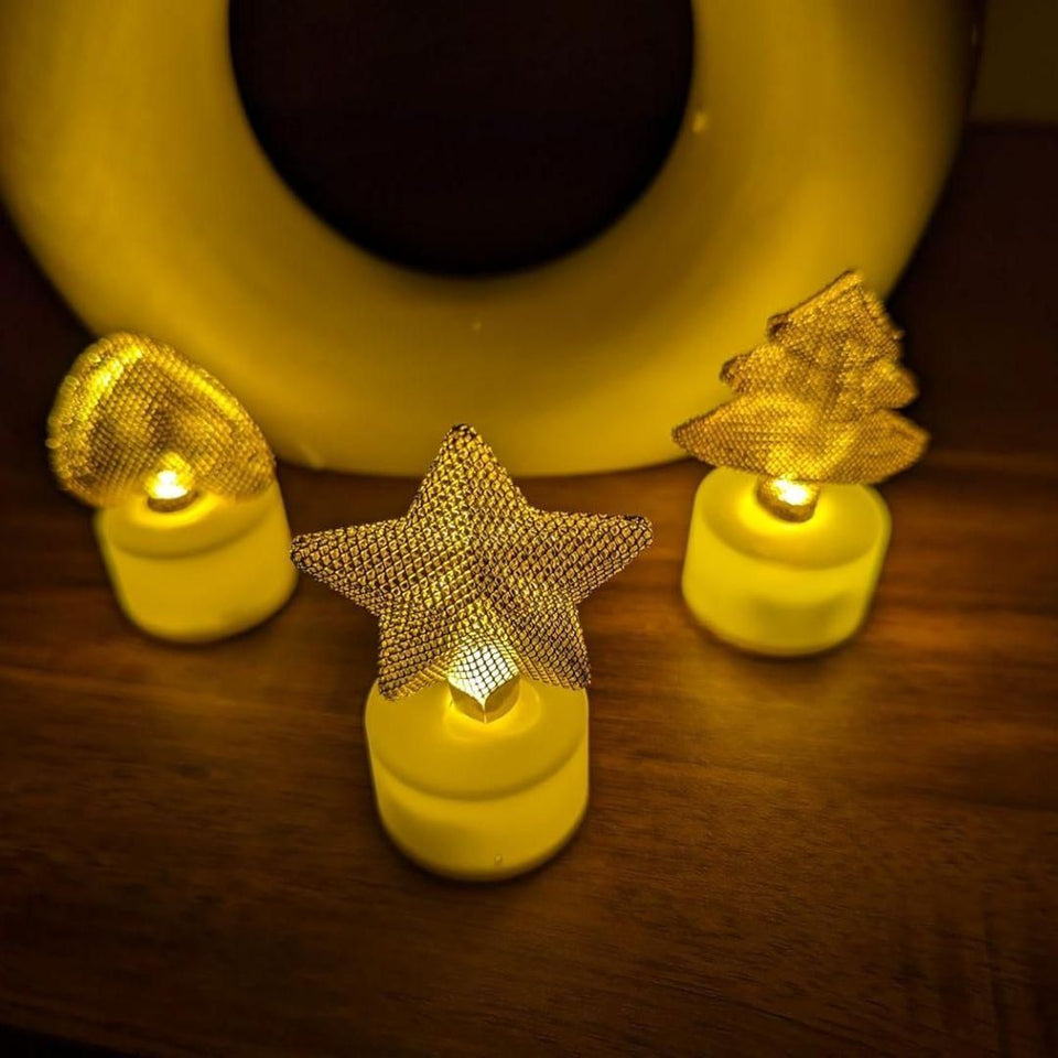 Decorative string lights with star and tree shapes on a wooden surface.