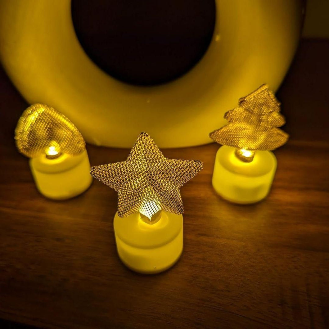 Decorative string lights with star and tree shapes on a wooden surface.