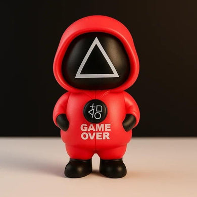 Toy figure in a red hood with 'GAME OVER' text on a dark background