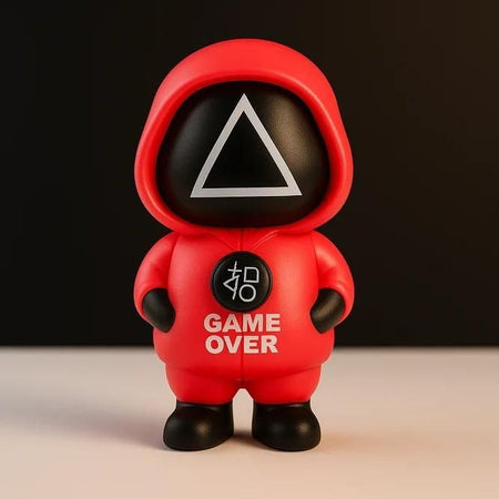 Toy figure in a red hood with 'GAME OVER' text on a dark background
